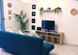 トリノにあるOlympic Hidden Houseの青いソファとテレビのあるリビングルーム
