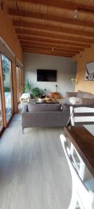 a living room with a couch and a flat screen tv at Casa de campo chiloe pugueñun ancud in Ancud