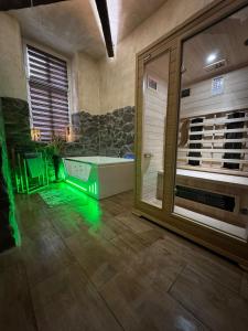a bathroom with a tub and a large glass window at Apartament Stodoła Spa z Jacuzzi,Sauna w Centrum in Bydgoszcz