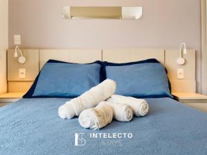 two towels on a blue bed in a bedroom at Living in Poços de Caldas +35 photos