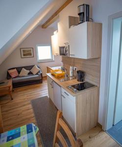 a kitchen with a sink and a living room at Schöne Ferienwohnung In Oberwaldbach in Burtenbach