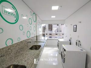 a bathroom with a sink and a washing machine at Living in Poços de Caldas