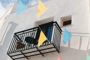 a white building with flags on a balcony at La Parcela in Peñíscola