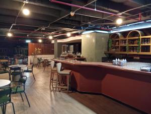 a bar in a restaurant with tables and chairs at Hotel Rulay Medellin in Medellín