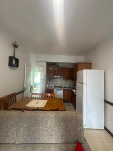 a kitchen with a table and a white refrigerator at Apartamento para diárias in Quarteira