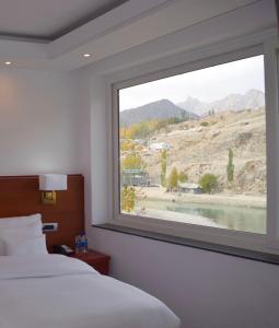 a bedroom with a large window with a view at Hotel The Haven - Centrally Heated and Air Conditioned in Kargil