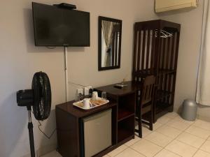 a room with a television and a desk with a fan at LePatino BnB in Livingstone