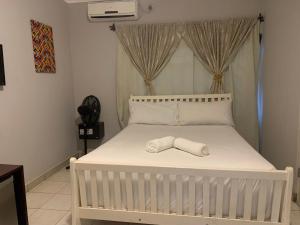 a white bed with a towel on it in a bedroom at LePatino BnB in Livingstone +11 photos