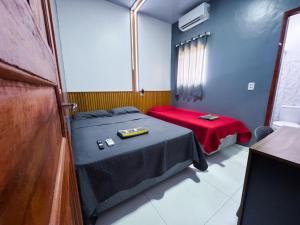 a small room with a bed and a red blanket at Hotel Saint Clara B in Belém