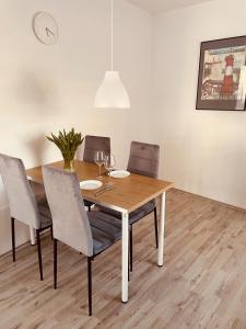 a dining room with a wooden table and chairs at Haus Nordwind in Wilhelmshaven