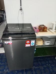a black refrigerator sitting in a kitchen next to a counter at Homestay Casa Mutiara in Paka