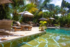 a pool with chairs and umbrellas next to a resort at Manaya Luxury Diani Beach Serviced 2Bedroom with Pool & Parking in Galu