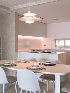 釜山にあるStay Villette Haeundaeのキッチン(テーブル、白い椅子、テーブル付)、ダイニングルームが備わります。