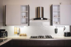 a kitchen with white cabinets and a stove top at Manaya Luxury Diani Beach Serviced 2Bedroom with Pool & Parking in Galu