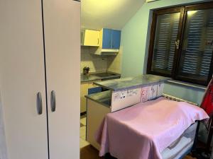 Una pequeña cocina con una mesa rosa en ella. en Kraljevacka 13, en Belgrado 1 foto más