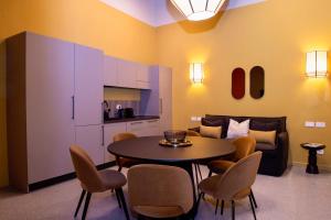 a living room with a table and chairs and a couch at Maison Luxury Plaza in Rome