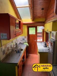 una cocina con fregadero y encimera en Cabañas Apiku, Lago Puelo, en Lago Puelo 7 fotos más