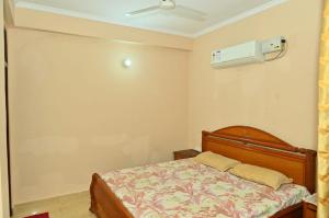 Un dormitorio con una cama y un ventilador de techo. en JD Homestays, en Jaipur