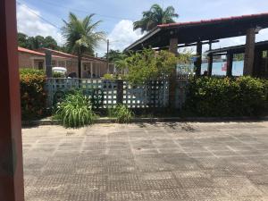 una valla frente a un edificio con plantas en Linda casa de Itamaraca, en Itamaracá