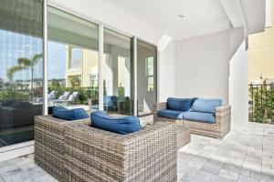 un patio con 2 sofás azules en un edificio en LC517T The Chic Abode at Liberty Bluff, en Kissimmee