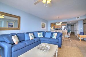 a living room with a blue couch and a table at Crescent Shores North - 1302 in Myrtle Beach