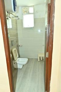 Un pequeño baño con inodoro y ventana. en JD Homestays, en Jaipur