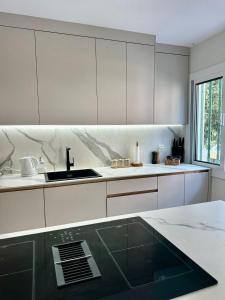 a kitchen with white cabinets and a sink at Picasso 2 Royale in Marbella