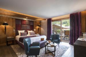 a hotel room with a bed and two chairs at MGM Hôtels & Résidences - Hôtel Les Suites d'Alexane in Samoëns
