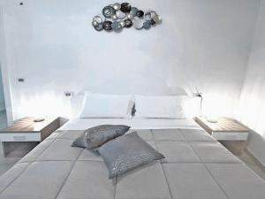 un grand lit blanc avec deux oreillers dessus dans l'établissement AuGuStea-The Nest of Sannicandro, à Sannicandro di Bari