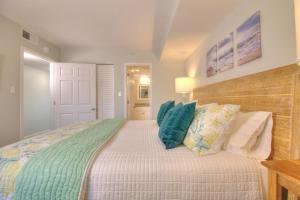 a bedroom with a large bed with blue pillows at Verandas - 303 in Myrtle Beach +41 photos