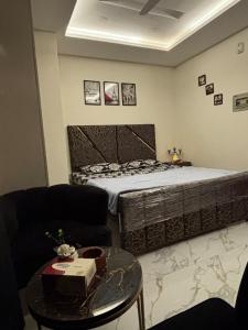 a bedroom with a bed and a table and a couch at The little nest in Islamabad +2 photos