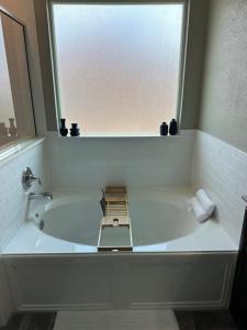 a white bath tub with a window in a bathroom at Relax with Spacious Modern Simplicity in Boerne +23 photos