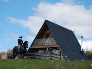 a person riding a horse in front of a house at Mountain house Tomislavgrad with Jacuzzi in Tomislavgrad