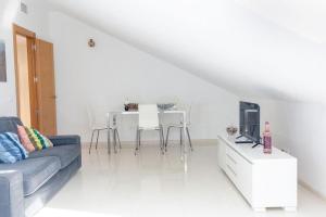 a living room with a couch and a table with a tv at NT Bright and modern apartment in Pizarra in Pizarra