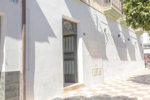 a white building with a door on a street at NT Bright and modern apartment in Pizarra in Pizarra