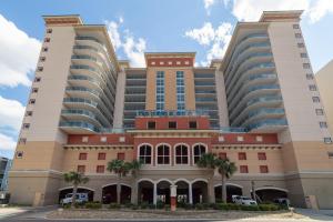 a large building with palm trees in front of it at Bahama Sands - 704 in Myrtle Beach