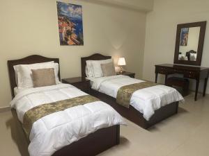a bedroom with two beds and a table with a mirror at Samaraham Residency in Indāf +41 photos
