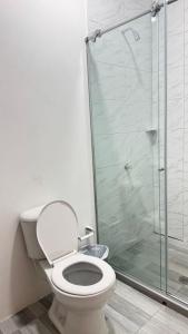 AracatacaにあるHotel, Restaurante DON ALBERTOのトイレとガラスのシャワー付きのバスルーム