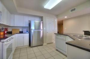 a kitchen with a stainless steel refrigerator and white cabinets at Barefoot Yacht Club Villas - 1-805 in Myrtle Beach