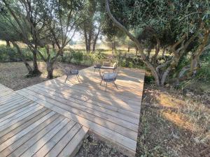 two chairs and a table on a wooden deck at Cap d'Agde Chalet Prestige Calme Piscine Plage in Agde