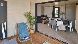 a living room with a mirror and a dining room at Cap d'Agde Chalet Prestige Calme Piscine Plage in Agde