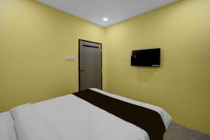 Pedda AmbarpetにあるHotel O Royal Plazaのベッドと薄型テレビのある寝室