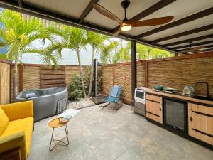 a patio with a tub and a kitchen with a ceiling fan at Deluxe Boutique Apartments Sonrisa - Adults only in Kralendijk