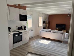 un soggiorno con un divano bianco e una cucina di Appartement en duplex proche de la mer a Plérin