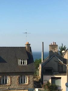 vista di una casa con l'oceano sullo sfondo di Appartement en duplex proche de la mer a Plérin
