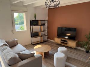 un soggiorno con divano e TV a schermo piatto di Appartement en duplex proche de la mer a Plérin