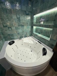 a white tub in a bathroom with a mirror at Arandi Baserria in Murueta-Orozko