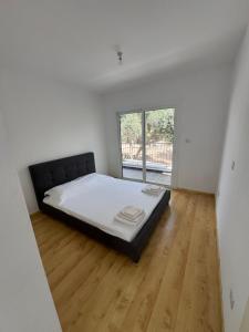 a bedroom with a bed in a room with a window at Peyia Sunset Luxury in Paphos City