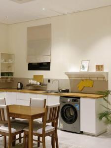 a kitchen with a table and chairs and a dishwasher at The Nest Loft in Riyadh