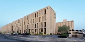 a large building with cars parked in a parking lot at The Nest Loft in Riyadh